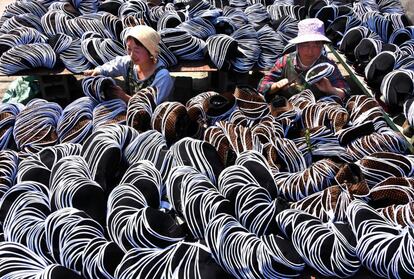 Empleados trabajan en zapatos de tela tradicionales en el condado de Yiyuan, provincia de Shandong, China.