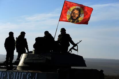 Un grupo de milicianos prorrusos sobre un carro de combate en el que ondea un bandera con la cara de Jesucristo, en la región de Donetsk, Ucrania.