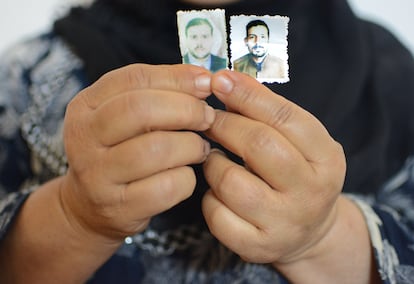 Las manos de Hadia Halil sosteniendo las fotos que conserva de sus dos hijos desaparecidos en 2016, Qahtan de entonces 37 años y Mohamed, de 31. Pincha en la imagen para ver la fotogalería completa.