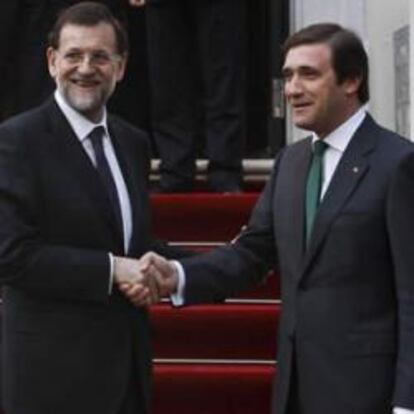 El primer ministro portugués, Pedro Passos Coelho, saluda al presidente del Gobierno español, Mariano Rajoy, antes de la reunión que han mantenido en el Palacio de Sao Bento, en Lisboa