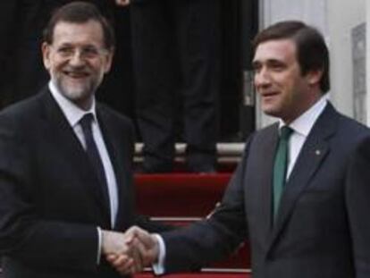 El primer ministro portugués, Pedro Passos Coelho, saluda al presidente del Gobierno español, Mariano Rajoy, antes de la reunión que han mantenido en el Palacio de Sao Bento, en Lisboa