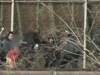 Fotograma del vídeo donde se ve cómo un migrante es apaleado por varios agentes tras bajar de la valla fronteriza de Melilla.