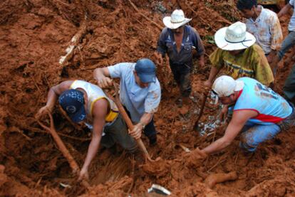 Varias personas intentan rescatar cuerpos atrapados tras el derrumbe de un cerro en la localidad mexicana de Amatán.