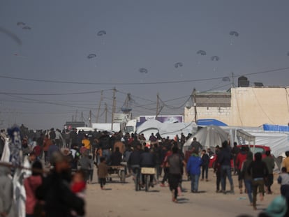 Una multitud de gazatíes corría a recoger la ayuda lanzada en avión sobre la Franja, el miércoles.