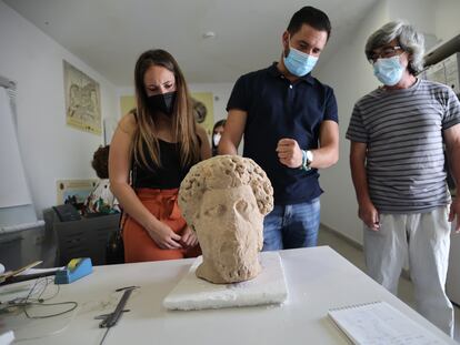 Los concejales Davinia Calderón y Daniel Caballero y el director del museo de Medina Sidonia, Salvador Montañés, inspeccionan una cabeza romana donada por Francisco Guerra.