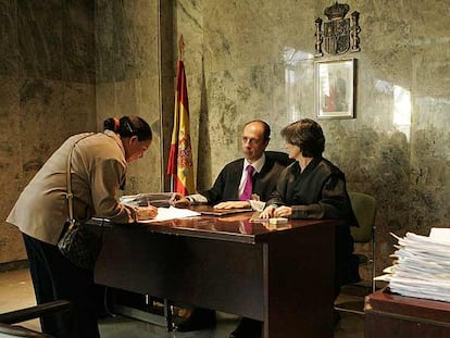 Una inmigrante firma su juramento de fidelidad a la Constitución y al Rey, en el Registro Civil de Madrid