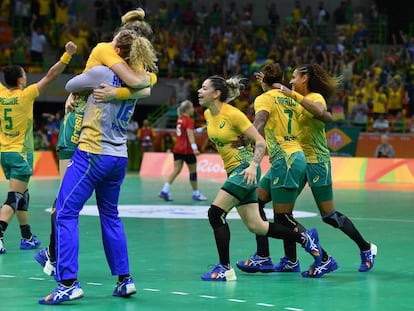 A equipe feminina de handebol comemora a vitória.