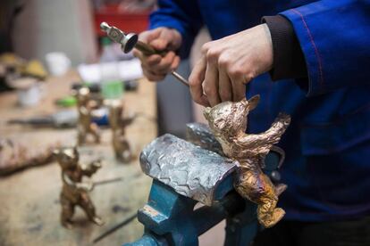 Un empleado retoca un oso de bronce que será entregado en la Berlinale.