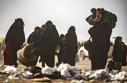 Mulheres com filhos deixam Baghuz arrastando seus pertences, em 5 de março, na província síria de Deir Ezzor. Atordoadas pelo confronto de batalhas e empobrecidas, centenas de mulheres abandonaram, com seus filhos, o último bastião do Estado Islâmico com uma pequena bagagem.