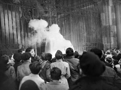 Unos niños ven cómo arde la efigie de Papá Noel en la catedral de Dijon (Francia), el 24 de diciembre de 1951.