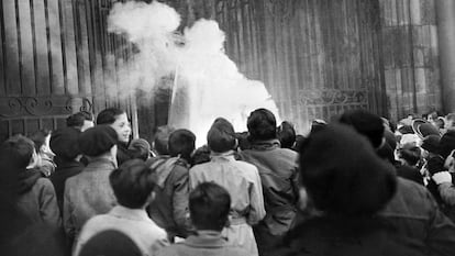 Unos niños ven cómo arde la efigie de Papá Noel en la catedral de Dijon (Francia), el 24 de diciembre de 1951.