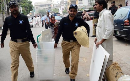 Polic&iacute;as paquistan&iacute;es portan urnas y otros materiales para las elecciones, este viernes en Lahore.