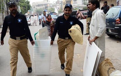 Policías paquistaníes portan urnas y otros materiales para las elecciones, este viernes en Lahore.