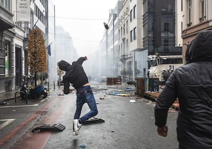 Un manifestante lanza un objeto contra las fuerzas de seguridad, este domingo en Bruselas.