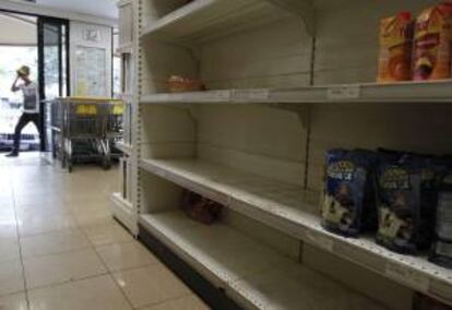 Un hombre entra en un supermercado con estanterías desabastecidas en Caracas (Venezuela). EFE/Archivo