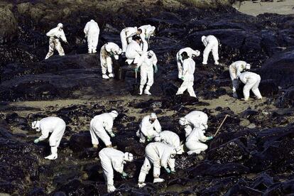 Voluntarios recogen chapapote en la Costa da Morte (Galicia) el 6 de diciembre de 2002. El naufragio del petrolero Prestige causó uno de los mayores desastres naturales en la historia de España. La marea negra afectó a 2.000 kilómetros de costa y movilizó a miles de voluntarios.