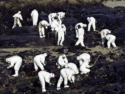 Voluntarios recogen chapapote en la Costa da Morte (Galicia) el 6 de diciembre de 2002.