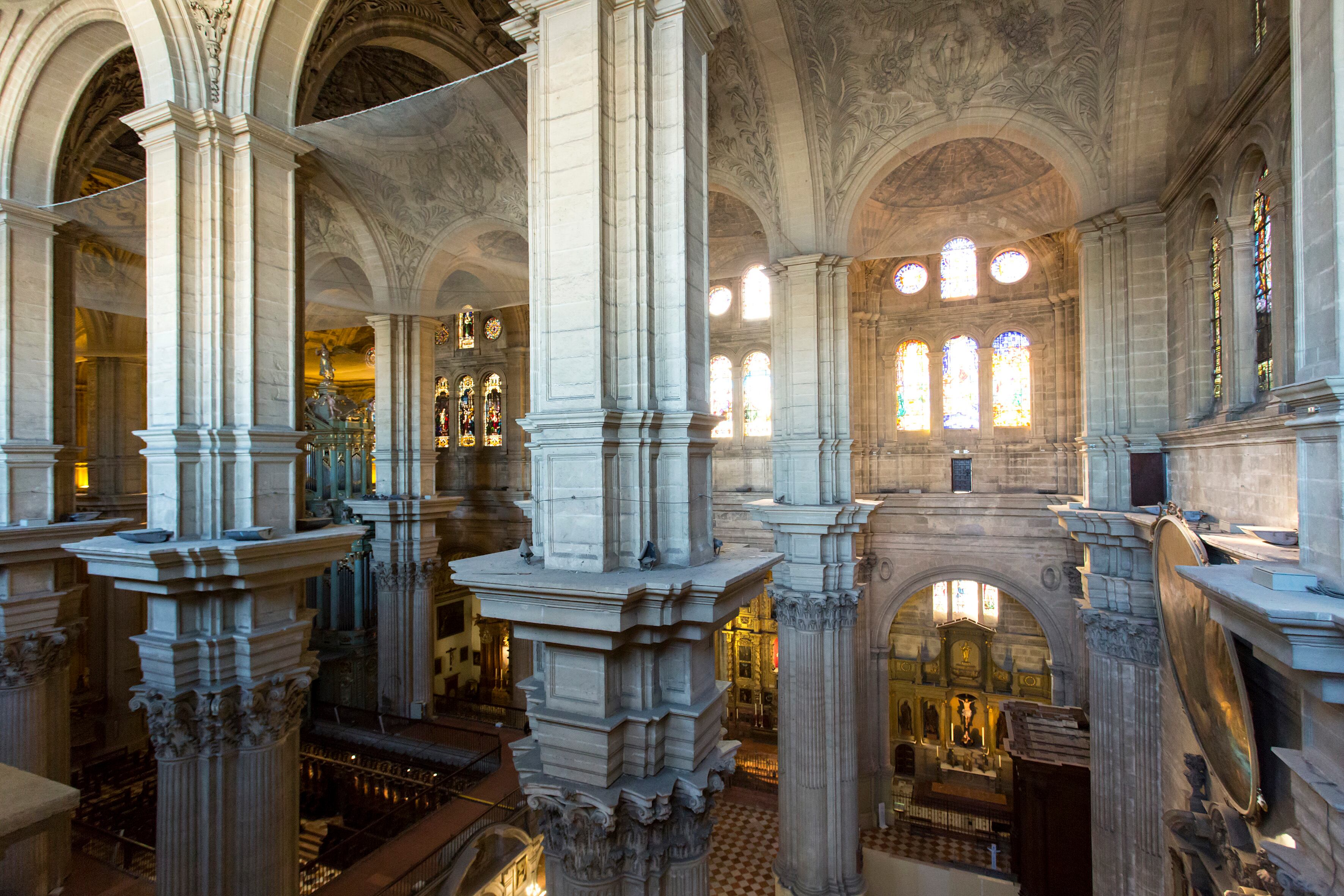 Redes bajo las bóvedas de la catedral de Málaga para proteger a los visitantes de la humedad y posibles desprendimientos.