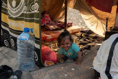 Surayya, una niña siria de un año y medio, sale gateando de su tienda.

