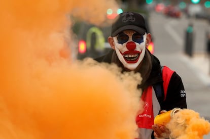 Un protestante con la cara pintada de payaso sostiene un bote de humo durante una manifestación convocada en el marco de la huelga general francesa contra la reforma de las pensiones en Marsella (Francia).