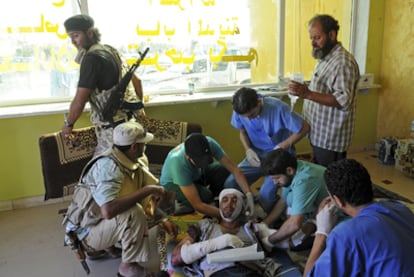 Un soldado rebelde es atendido tras resultar herido a las afueras de Sirte, una de las cuatro ciudades controladas por Gadafi.