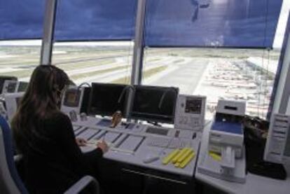 Una controladora en la torre de Barajas. De fondo, varios aviones de Iberia.