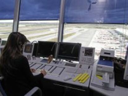 Una controladora en la torre de Barajas. De fondo, varios aviones de Iberia.