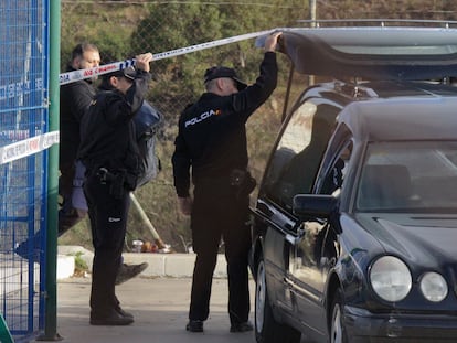 Agentes de la Policía junto al coche fúnebre que traslada el cadáver del menor, este lunes en Ceuta.