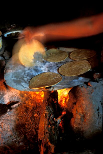 Una mujer prepara unas tortillas de maíz en comal en el Rancho La Rosa (Apulco).