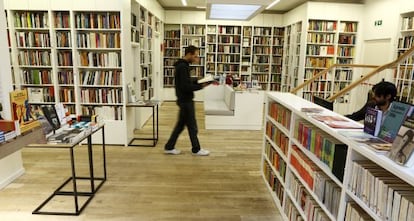 Un hombre camina mientras lee un libro en la librería Juan Rulfo, en Madrid.