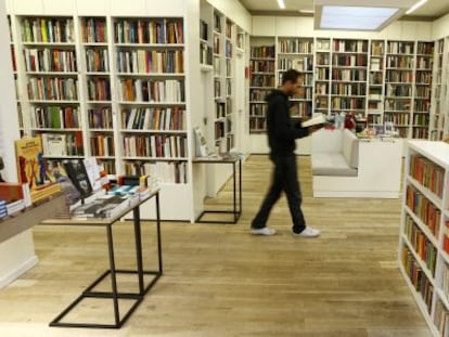 Un hombre camina mientras lee un libro en la librería Juan Rulfo, en Madrid.