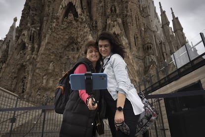 Dues turistes es fotografien davant de la Sagrada Família.