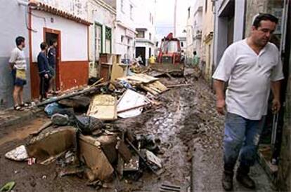 Vecinos de San Andrés presencian la retirada de lodo y enseres de sus casas inundadas por las lluvias torrenciales del pasado domingo.