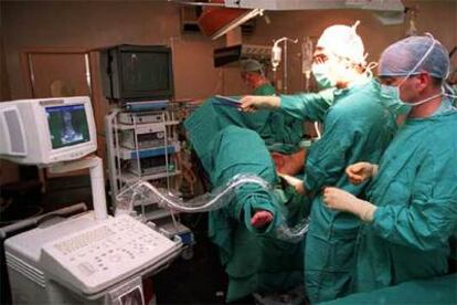 Un equipo de médicos opera a un paciente en el quirófano de un hospital.