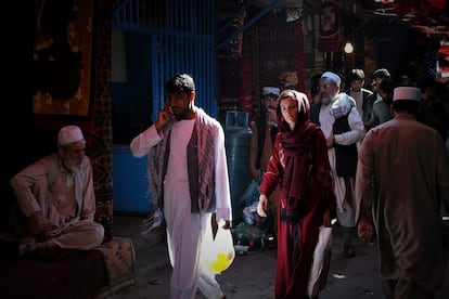 Una mujer transita entre hombres por las calles del bazar Mandawi de Kabul.