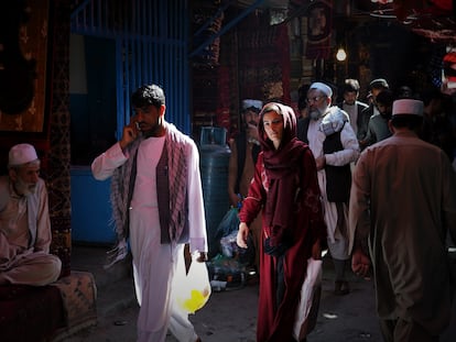 Una mujer transita entre hombres por las calles del bazar Mandawi de Kabul.