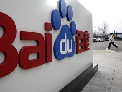 Una mujer camina junto al logotipo de Baidu en su sede de Beijing.