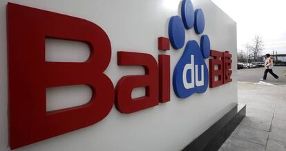 Una mujer camina junto al logotipo de Baidu en su sede de Beijing.