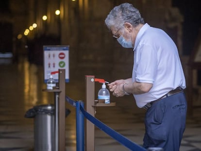 Un hombre usa un dispensador de gel hidroalcohólico en la catedral de Sevilla. 