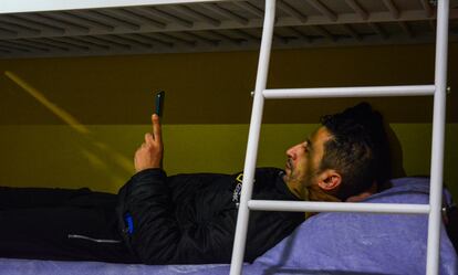 Un huésped de Hostel Nápoles consulta su teléfono mientras reposa sobre su litera.