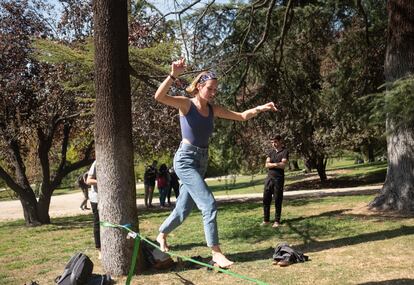 Laura Scrig, 23 años, en un parque cerca de Moncloa practicando slackline. Laura tiene programado un viaje para este puente a Bilbao y todavía no sabe si podrá ir.
