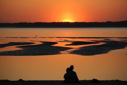 Una pareja observando la puesta de sol en el cabo Ferret en la Bahía de Arcachón, en Francia, el 8 de abril de 2017.