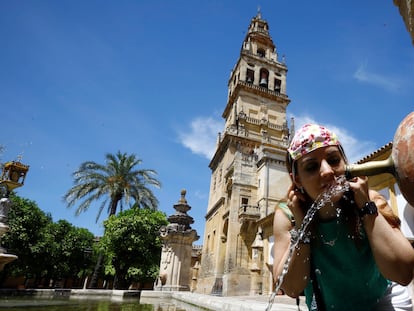 Una turista se refresca en la fuente del patio de los naranjos de la Mezquita-Catedral de Córdoba, este sábado.