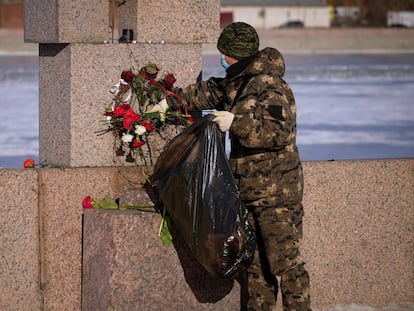 Un trabajador municipal retira las flores colocadas en memoria de Navalni en un monumento a las Víctimas de la Represión Política, en San Petersburgo, este lunes.