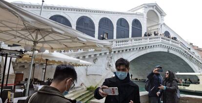 Turistas con mascarillas posan en Venecia.