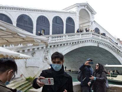 Turistas con mascarillas posan en Venecia.