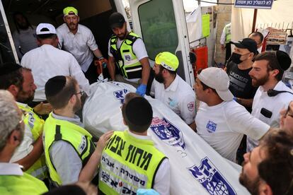 Equipos de rescate trasladan un cadáver a una ambulancia, este viernes.