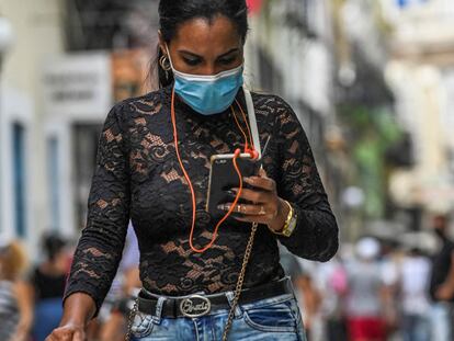 Una mujer camina por una calle de La Habana (Cuba) mirando su teléfono, en julio de este año.