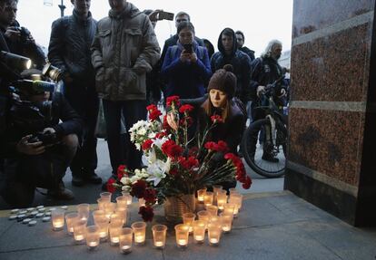 Varias personas depositan flores y velas por las víctimas del atentado terrorista ocurrido en el metro de San Petersburgo.