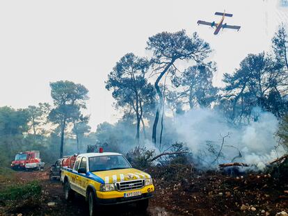 Los vehículos equipados del colectivo anarquista Rouvikonas participan en la extinción de un incendio junto a medios aéreos y terrestres de los bomberos, cerca de Eipdauro, Grecia.
